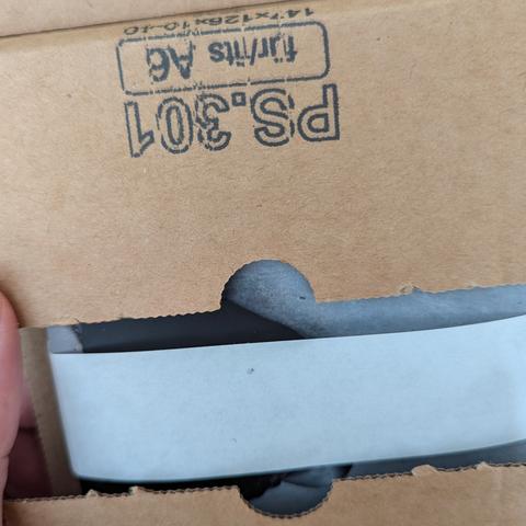 Partially opened brown cardboard packaging with a glimpse of its contents