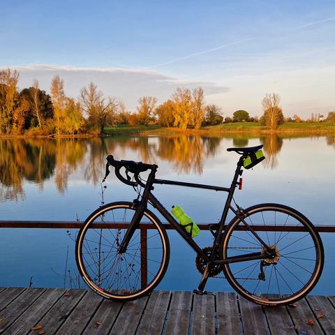 Velo de route au bord d'un des lacs de la Ramée en automne