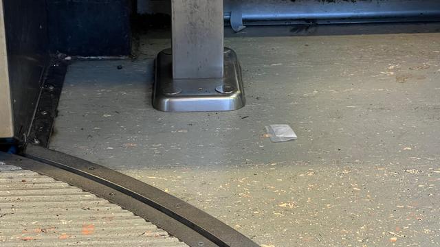 a clear, 2in ziplock bag partially filled with white powder sits, folded in half, on a formica-flecked dirty floor, beneath a seat on Portland's MAX Trimet public transit.