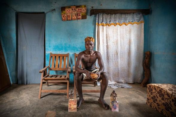 A voodoo believer showing the images of his ancestors and traditional talismans used to communicate with their spirits (Benin).

In voodoo, a hollowed-out gourd used as a container holds strong symbolic and ritual significance.
Used as a container in voodoo is a powerful spiritual symbol, utilized to contain and interact with invisible forces, offer tributes to spirits, or protect its owner. Its exact meaning depends on the contents and the specific ritual context.
It may represent the human body or the universe, encapsulating vital essence. It is often used to store spiritual energies, talismans, or offerings to the spirits.
The gourd, can be also a tool for communicating with spirits. It can be filled with sacred objects such as herbs, ritual powders, shells, or symbols of the voodoo spirits. They serve to invoke and maintain a connection with spiritual entities, protect the owner, or attract good fortune.
Others meaning of the gourd may be for protection, offering to gods or ancestors, tool for purification and healing, symbol of fertility and abundance.

Website: <a href="https://www.robertopazziphoto.com/" rel="noreferrer nofollow">www.robertopazziphoto.com/</a>

Instagram: <a href="https://www.instagram.com/roberto_pazzi_photo/" rel="noreferrer nofollow">www.instagram.com/roberto_pazzi_photo/</a>