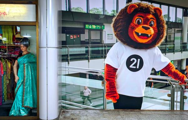 A mannequin in a green sari poses stylishly next to a large lion mascot with a white T-shirt.

Eine Schaufensterpuppe in einem gruenen Sari posiert stilvoll neben einem grossen Loewen maskottchen mit weissem T-Shirt.