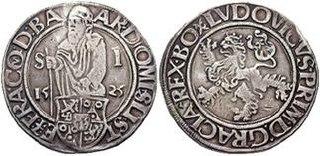 Eine Münze, die auf beiden Seiten geprägt ist. Auf der einen Seite ist ein stehender, lange gekleideter Mann abgebildet, umgeben von Schriftzeichen. Auf der anderen Seite ist ein stilisierter Löwe zu sehen, ebenfalls mit umgebender Schrift. Die Münze hat eine runde Form und zeigt klare Details der Prägung.