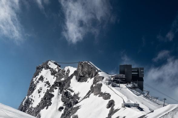 Hängebrücke zwischen zwei Berggipfeln in den Waadtländer Alpen aus der Distanz fotografiert.