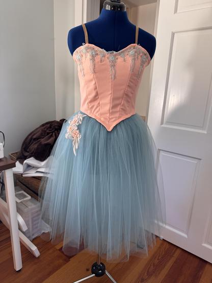 Peach bodice with attached pale blue tutu on a dress form