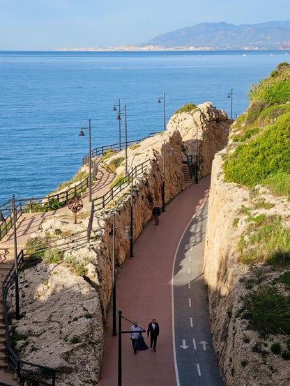 A railway cutting with no railway through cliff beside a bay