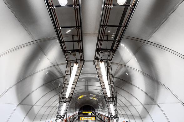 Wide angle symetrical shot of the white curved ceiling of one of the platforms of the metro station Florenc in Prague. The shadows of the lamps and other objects hanging from the ceiling draw a giant rabbit head over the ceiling.