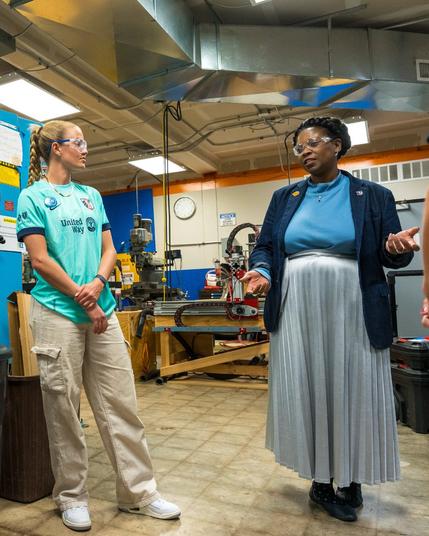 Regan Steigleder stands next to a woman in the STEM lab who is speaking.