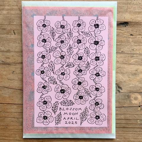 The cover of a glassine envelope that has an illustrated design of blossom and leaves, for the blossom moon of April.
