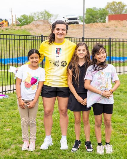 Laurel Ivory smiling and posing with Girls on the Run participants
