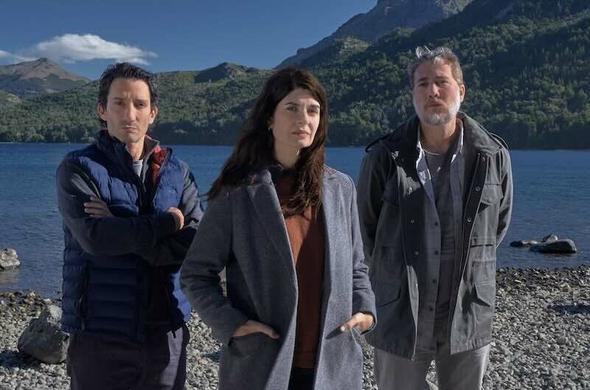 Standing by a lake with mountains in the back ground are Soledad Villamil, Juan Minujín, and Alberto Ammann. They are the main characters in the series Caught.