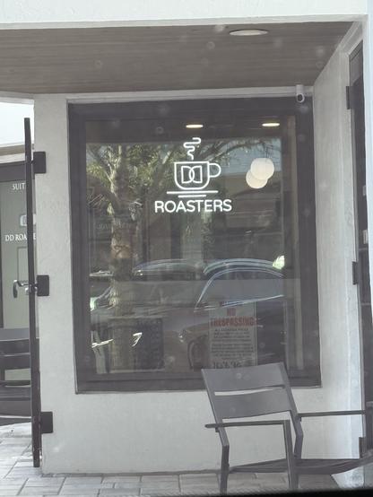 A storefront featuring a sign that says "DD ROASTERS," accompanied by a graphic of a coffee cup with steam. The double D refers to the bra size and not Dungeons and Dragons. Turns out.