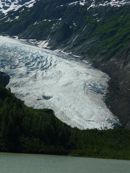 Ein Gletscher zwischen Bergen, dessen Kopf wie ein Drachenkopf oder ein Schlangenkopf geformt ist.