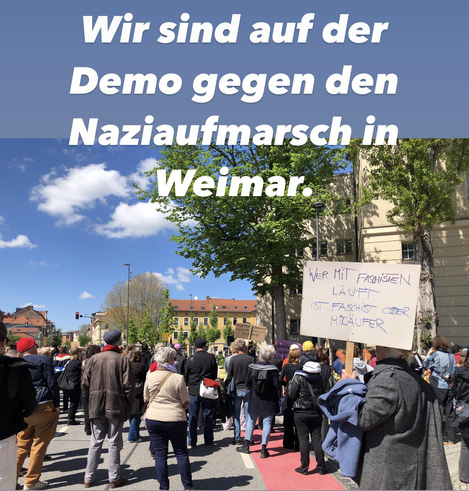 Viele Menschen von hinten zu sehen, die sich hinter  dem DNT in Weimar versammelt haben. Rechts eingrosser Baum und ein Mann, der ein Schild trägt, mit einem Text, der an die Demonstratem des Naziaufmarsch gerichtet ist: Wer mit Faschisten läuft ist Faschist oder Mitlàufer.
