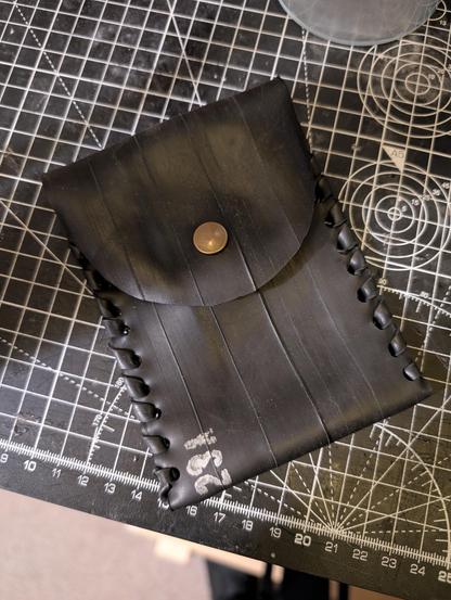 Photo of a pouch made from inner tube rubber with snap button closer and rubber threading