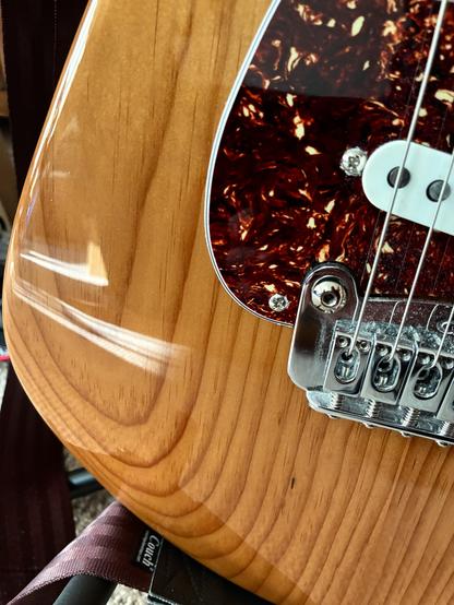 Closeup of tortise pickguard and E string on strat style guitar