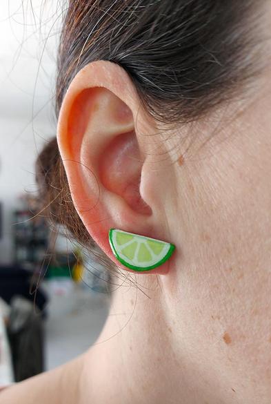 Puces d'oreilles fantaisie éco-responsables en forme de demies rondelles de citron vert.
Les perles sont réalisées en CD recyclé, découpées et peintes à la main, puis recouvertes de résine époxy.
Les tiges sont en acier inoxydable.