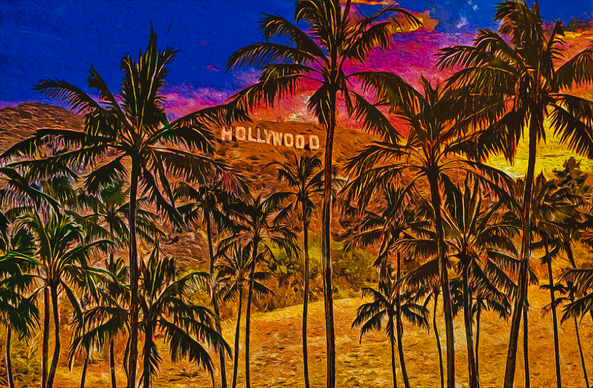 Holywood sign between palm trees at sunset