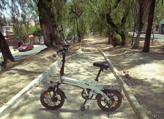 a photo of my ebike standing over a narrow path in the middle of a street.