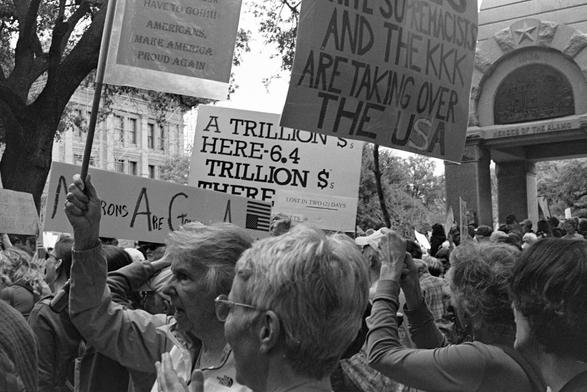 Protesters with signs in front of the Texas Capitol