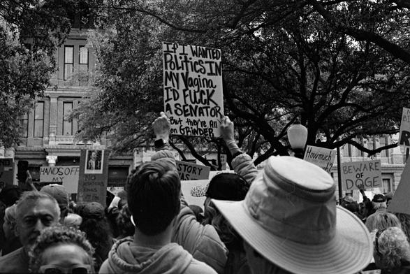 Protesters with signs in front of the Texas Capitol