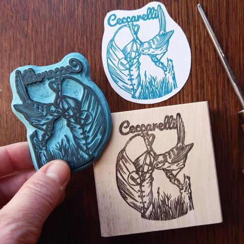 Tampon gravé à la main d'un logo sur lequel se trouve un petit oiseau en train d'assembler son nid. Tampon logo pour la boutique artisanale Ceccarelli.