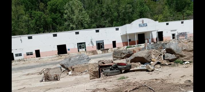 Closed business front with large chunks of rubble in front of it