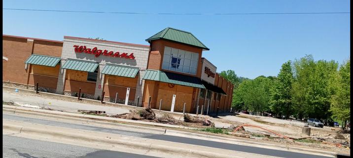 Walgreens parking lot with debris in front of it and boarded up