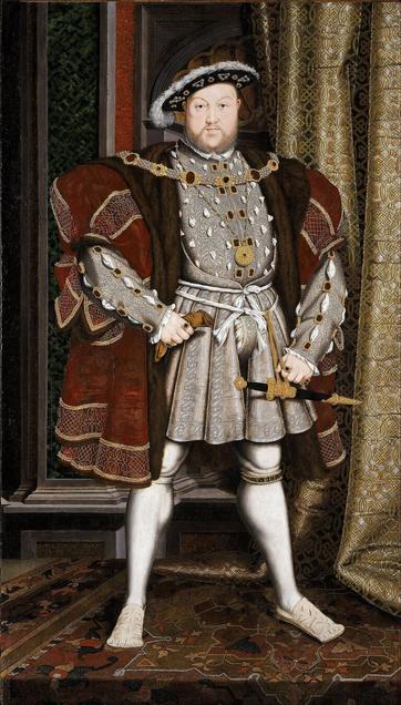 famous portrait of King Henry VIII of England, based on the work by Hans Holbein the Younger. The king is shown standing in a dominant, wide-legged stance with his hands on his hips, wearing opulent Tudor-era attire. His outfit includes a highly decorated doublet and tunic with intricate patterns and jewels, a fur-lined cloak, a codpiece, white hose, and flat shoes. He is adorned with heavy gold chains and a medallion, and a sword hangs at his side. Behind him is an ornate curtain and richly decorated surroundings, emphasizing his wealth and power.