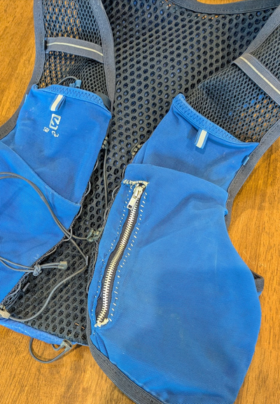 Blue running hydration vest with hand-sewn zipper replacement. The zipper is oversized, has metal teeth and doesn't fit with the rest of the vest.