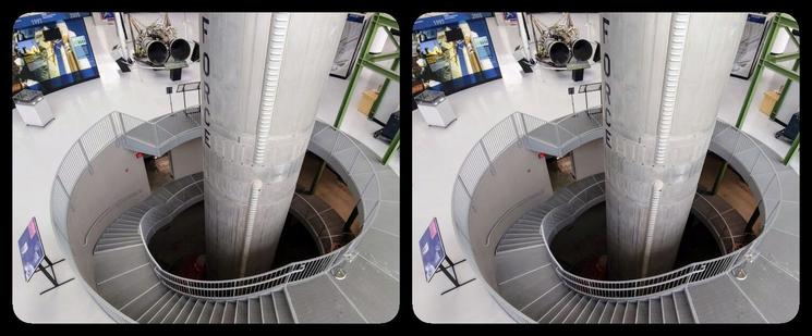 We're looking down towards an opening in a museum floor. A nuclear missile is coming out of it. The opening has a spiral staircase that goes around the lower part of the missile.