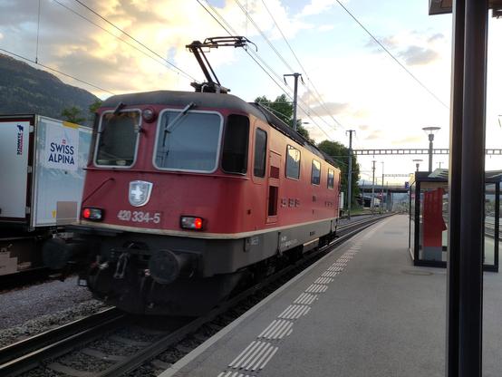 Foto. Eine rote Lokomotive im Bahnhof.