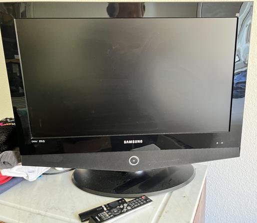 Ein ausgeschalteter Fernseher von vorne mit Fernbedienung.
