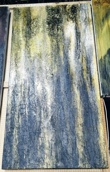 a tall vertical  painting of gold tones coming down vertically against a black backgound