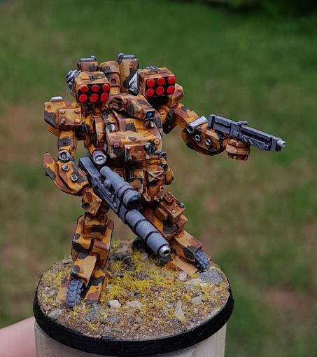 desert camouflage robot mech, covered in missiles and mortars, asymmetrically sized guns akimbo.  metal model painted with acrylics