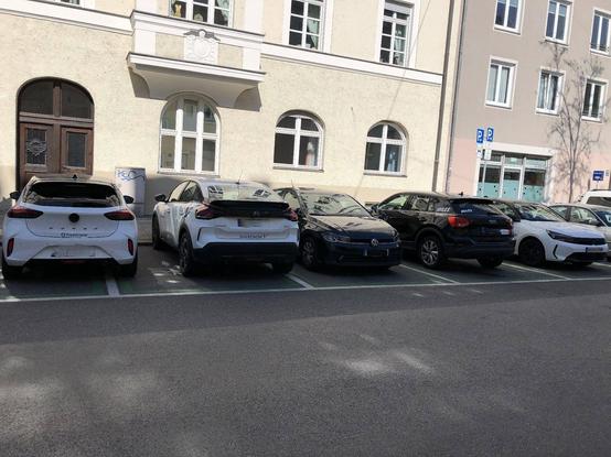 Fünf CarSharing Plätze auf öffentlichen Parkplätzen. Alle Plätze sind berechtigt durch entsprechende Fahrzeuge belegt.