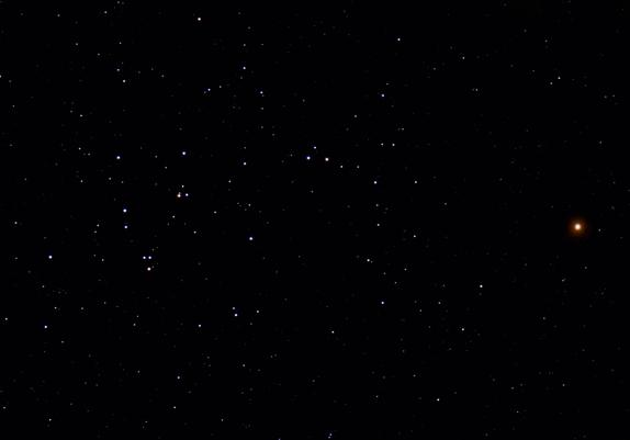 A starry night sky features the constellation Scorpius, with numerous white stars and one prominent orange-red star on the right side.