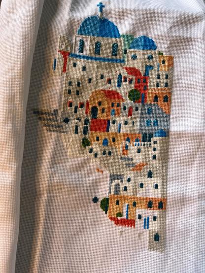 Stylised Santorini houses landscape almost half complete. The colours are blue, white, grey, peach and red