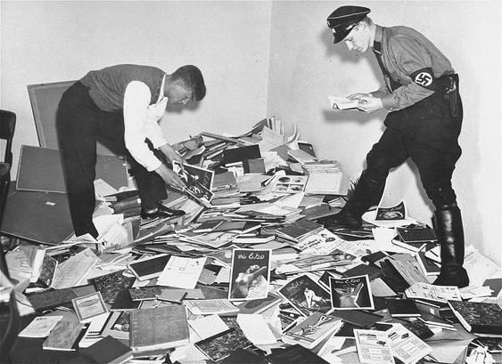 Nazi officers collect adult materials to burn.