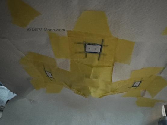 Bottom of the saucer covered with yellow masking tape and tissue paper leaving exposed the areas that need painted.