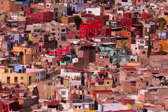 a photo of a mountain town from a high point of view, showing tens of small houses made out of bricks.