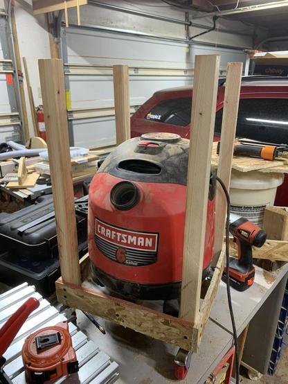 Frame with posts sitting on workbench with shop-vac sitting in the middle