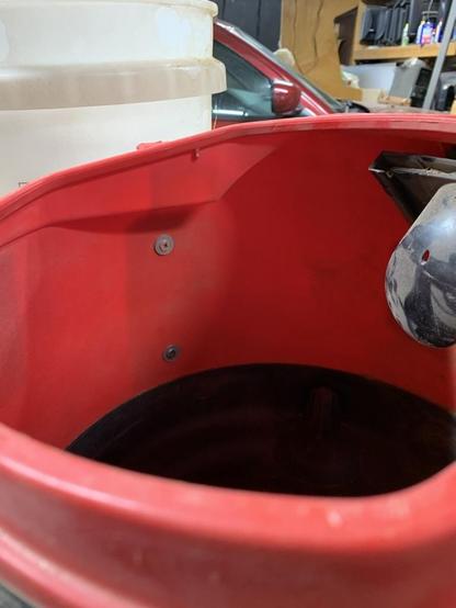 Looking inside the shop-vac with two screws going right through the plastic and out to the bucket.