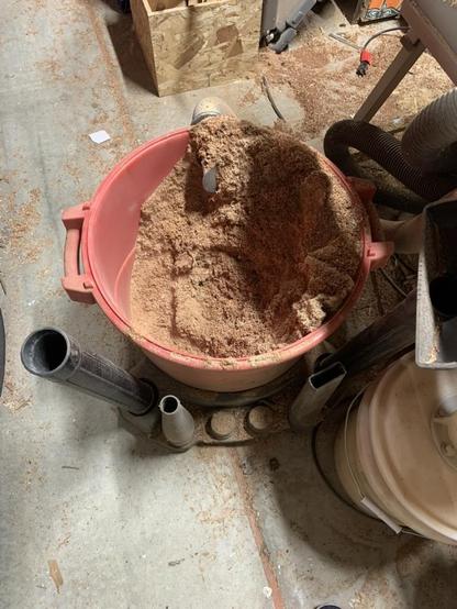 Inside of big shop-vac showing it’s overflowing with even more sawdust