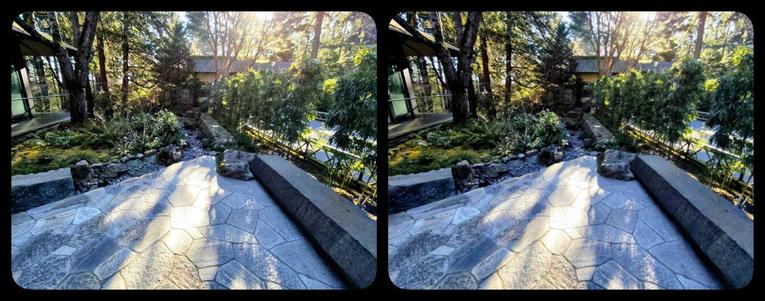A view behind a path at the Japanese garden. Flagstones lead back to a water trench.