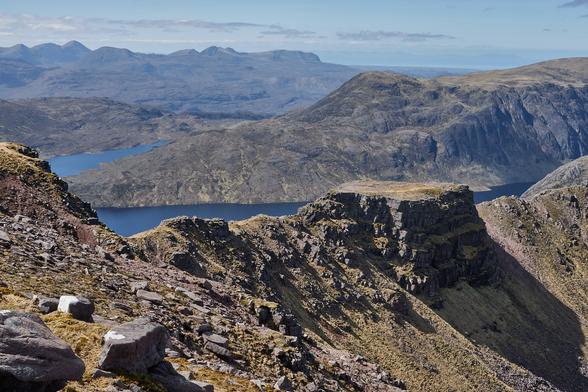 The 'tennis court' on the ridge to A' Mhaighdean. 

Whilst the scene is of mountain and lochs under a slightly hazing blue sky, the most striking feature is a flat topped area of the otherwise narrow rocky ridge.