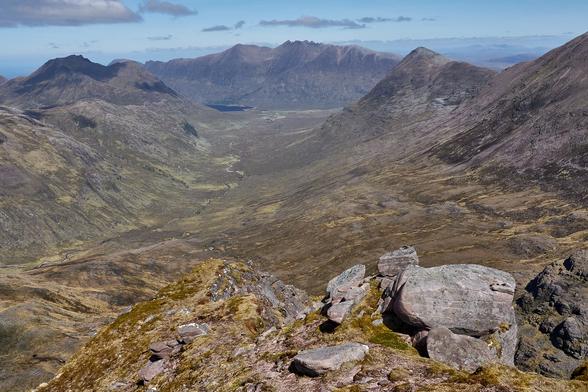 Between two rocky and dramatic ridges lays Gleann na Muice with the distinctive Corrag Bhuidhe pinnacles of An Teallach at the far end.