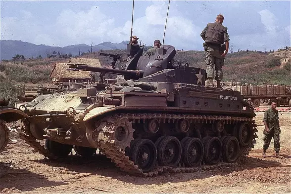The image appears to depict a military tank, likely a vintage model, with soldiers in military attire around it. The setting looks like a deployment or training ground, possibly in a rugged terrain with mountains in the background. The tank is likely from an earlier conflict, given its design and appearance.

Image Credits: Wikimedia / From the Robert L. Drieslein Collection (COLL/5643) at the Archives Branch, Marine Corps History Division / CC BY 2.0