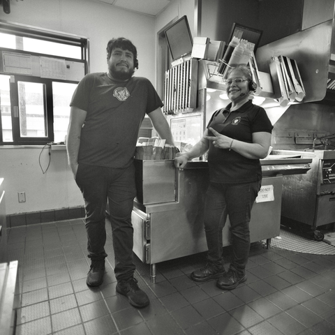 A black and white film photo. Alfredo and Maria are pictured inside the kitchen at Wendy’s. The restaurant was scheduled to be permanently closed the next day to make way for the I35 expansion in Austin, Texas. Saturday, April 26, 2025.