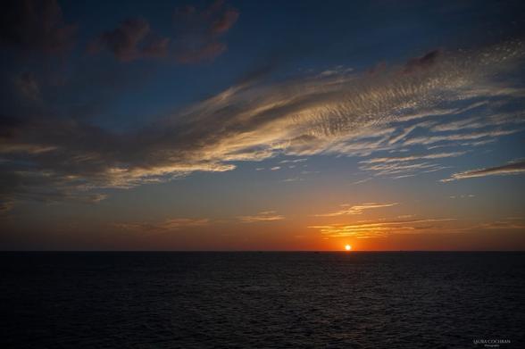 The sun sets over Playa del Carmen, as viewed across the sea, from Cozumel.