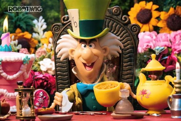 The Mad Hatter sits at a table drinking tea and eating a saucer. Unbirthday cake to his right with a candle burning on top. Doormouse appearing from teapot. Flowers in background